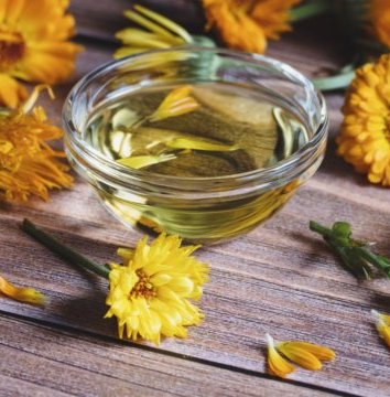 calendula-officinalis-cosmetic-oil-dried-and-fresh-marigold-flowers-on-wooden-table